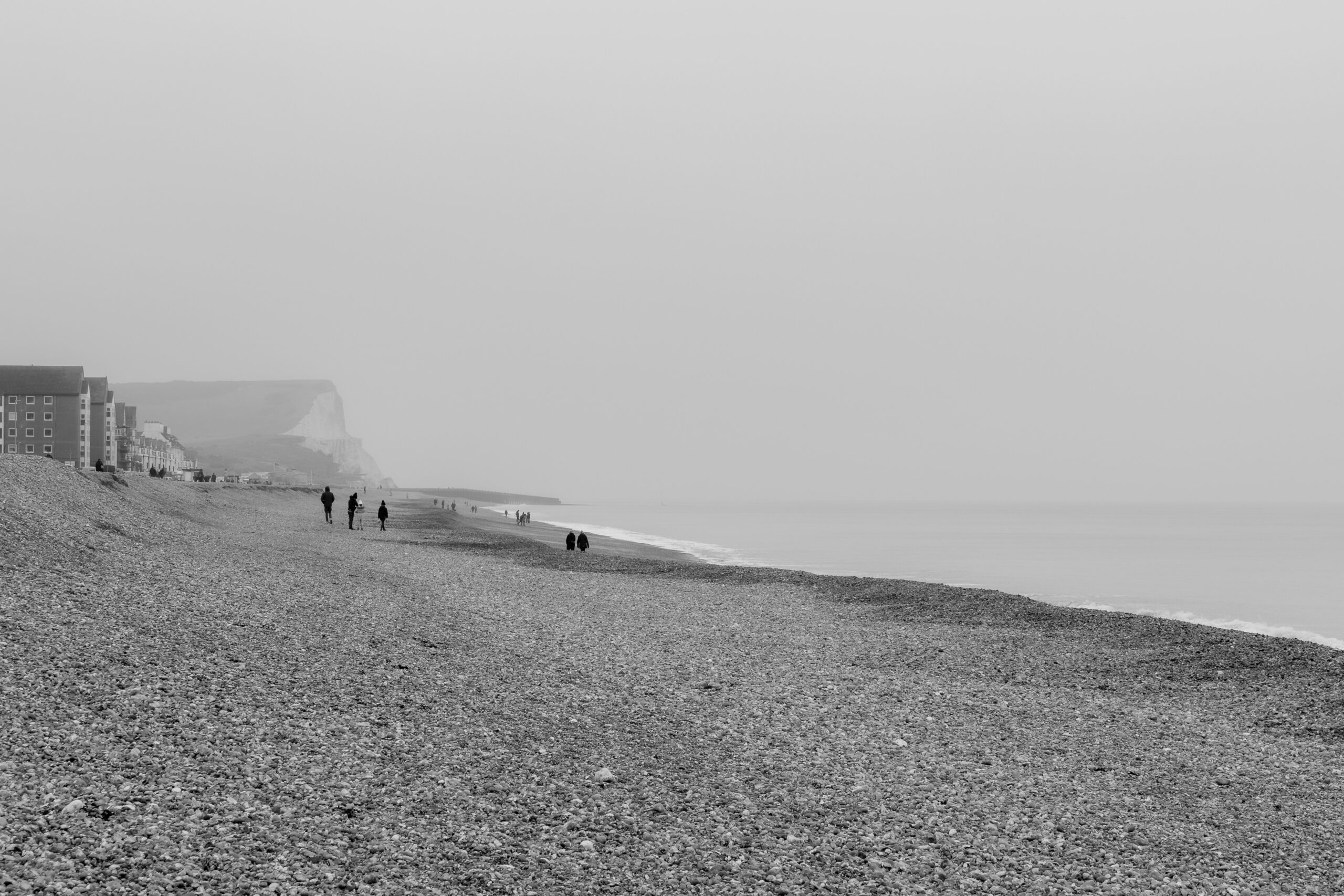 A black and white photo of seaford beach with the chalk cliffs in the background